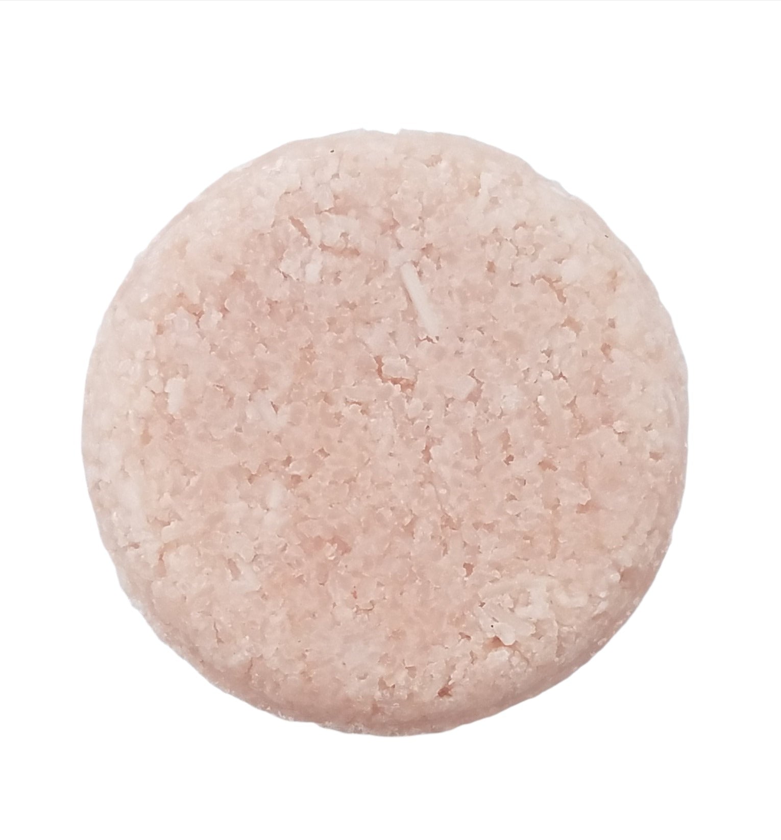 A round pink bar of shampoo